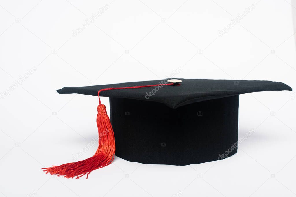 Black graduation cap with red tassel on white background