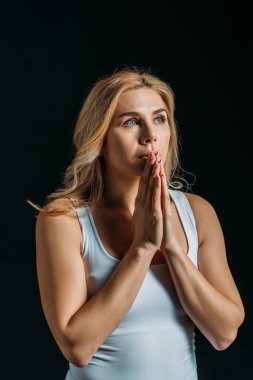 Beautiful woman praying isolated on black clipart