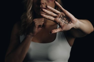 Cropped view of victim showing hand with help lettering isolated on black  clipart