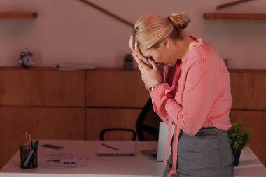 Yüzünü kapatan ve ofiste ağlayan kadınların seçici odak noktası