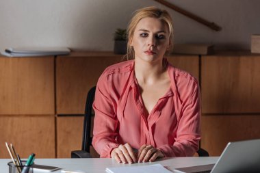 Ofiste oturan düşünceli bir kadının seçici odak noktası, cinsel taciz kavramı.