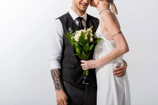 幸せな美しい入れ墨の花嫁とハンサムな新郎のキスのクロップドビューは白に隔離された — ストック写真