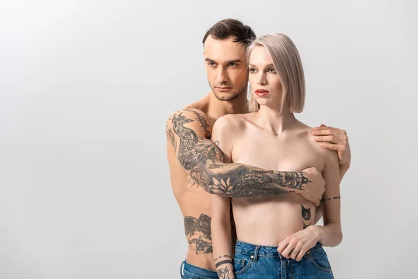 Jovem Sem Camisa Tatuado Casal Jeans Abraçando Isolado Cinza — Fotografia de Stock