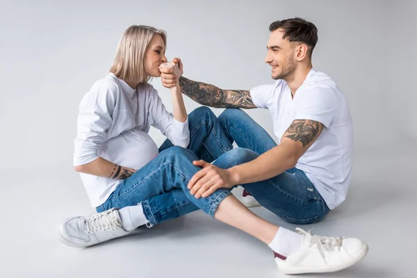 Young Tattooed Pregnant Woman Kissing Husband Hand Grey — Stock Photo, Image