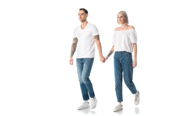 年轻的纹身夫妇手牵着手 孤零零地走在白色的路上 — 图库照片