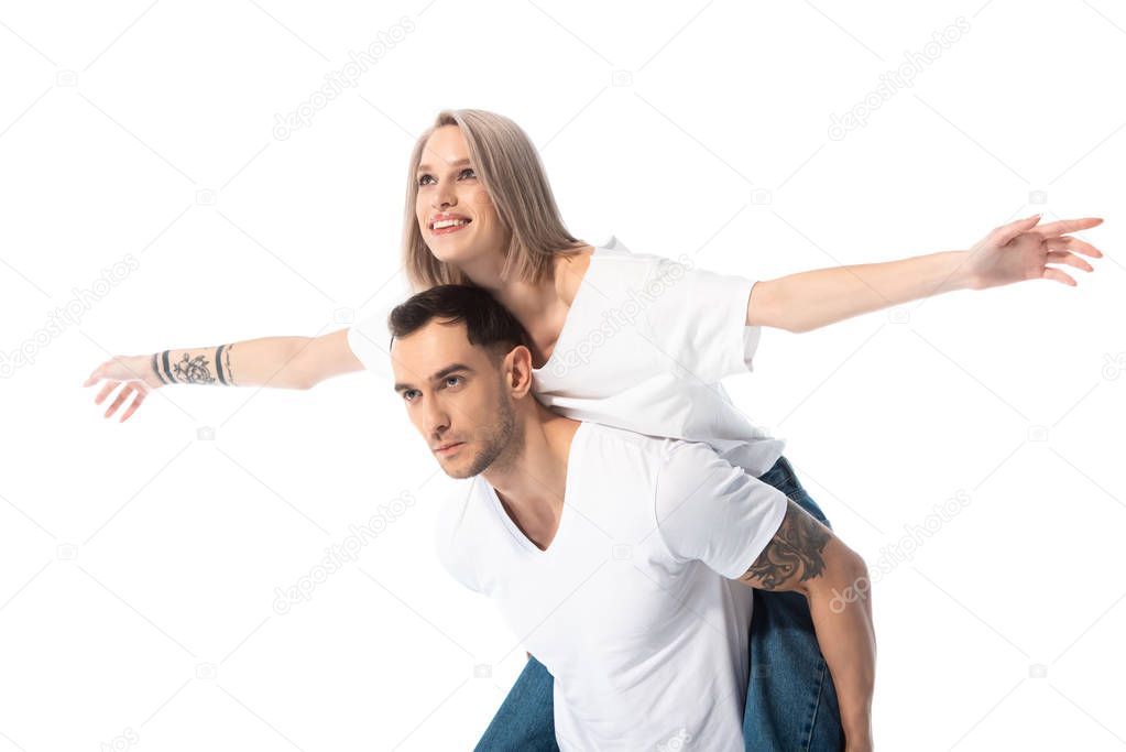 happy young tattooed couple piggybacking isolated on white