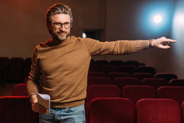 emotional stage director with scenario pointing on rehearse in theater  clipart