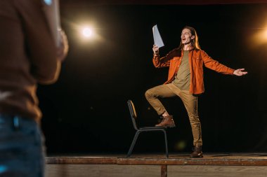 Senaryosu tiyatro yönetmeniyle prova yapan yakışıklı genç aktör.