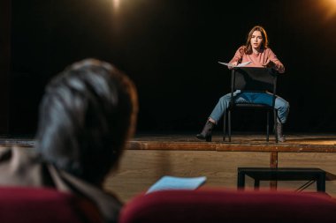selective focus of stage director and actress performing role with screenplay in theater clipart