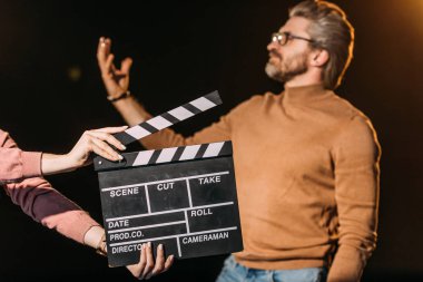 Yetişkin aktörlerin seçici odak noktası önünde clapboard ile rol yapmaları 