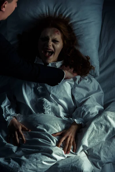 Exorcist Holding Yelling Female Demon Bed — Stock Photo, Image