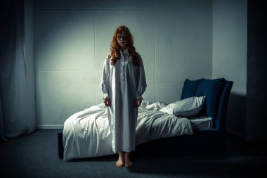 creepy demoniacal girl in nightgown standing in bedroom clipart