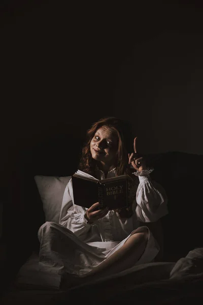 Demoniacal Girl Nightgown Reading Bible Pointing Bed — Stock Photo, Image