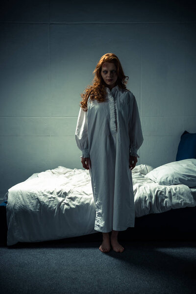 female demon in nightgown standing in bedroom