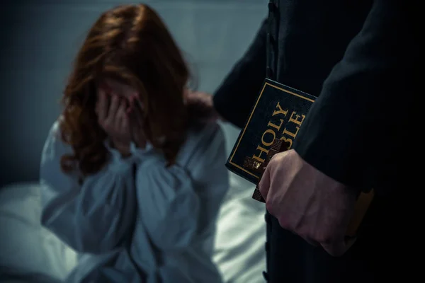 Exorzist Hält Bibel Und Umarmt Weinendes Mädchen Schlafzimmer — Stockfoto