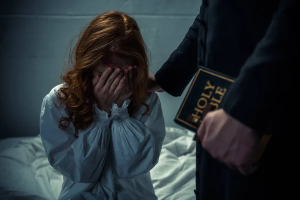 Exorzist Hält Bibel Und Umarmt Weinendes Mädchen Schlafzimmer — Stockfoto