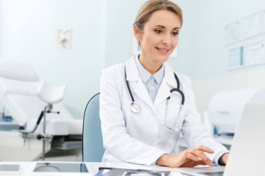 Klinikte dizüstü bilgisayarda çalışan profesyonel güzel bir doktor. 