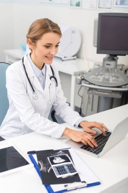 Masada ultrason taramalarıyla dizüstü bilgisayarda çalışan profesyonel bir kadın doktor. 