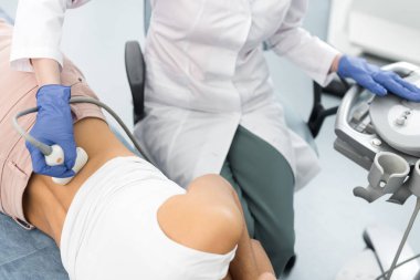 Klinikte ultrason taraması yapılan hastanın böbreğini inceleyen doktor görüntüsü.