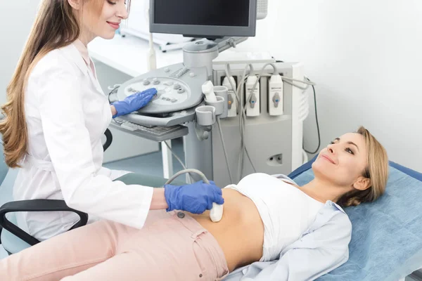 Sonriente Hermoso Doctor Examinando Estómago Mujer Paciente Con Ultrasonido Escanear —  Fotos de Stock