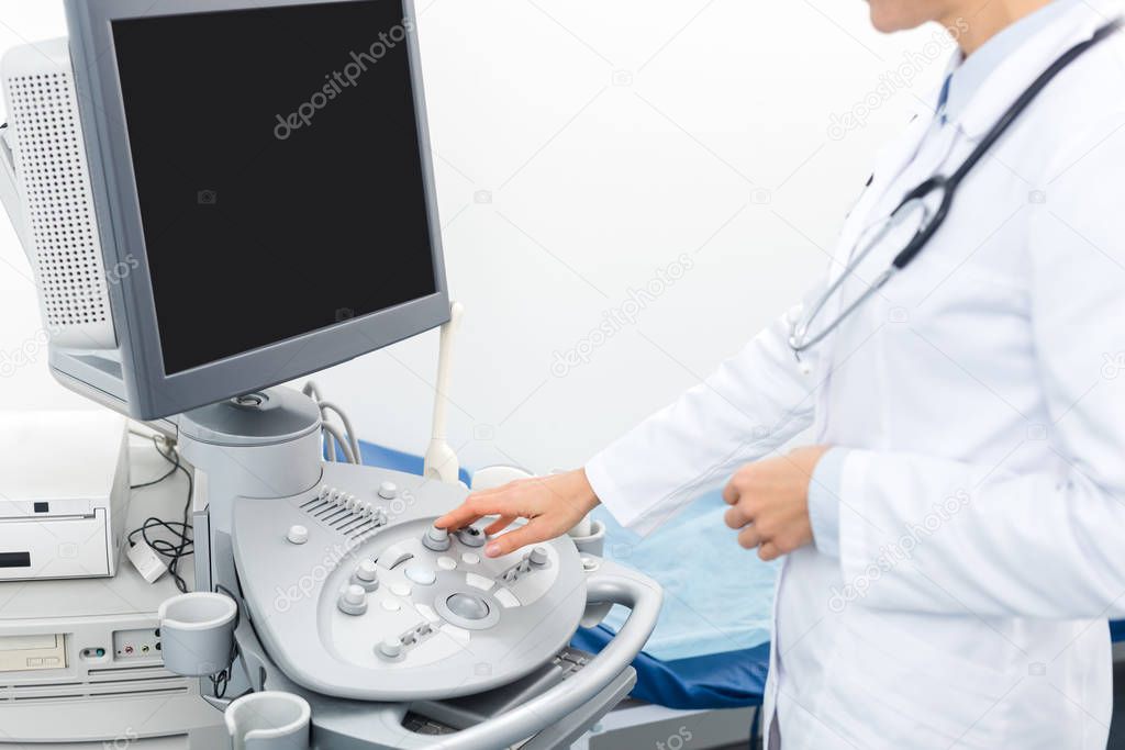 cropped view of doctor working with ultrasound scanner with blank screen 