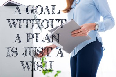 Cropped view of businesswoman holding paper folder and opening cabinet driver on white background, a goal without a plan is just a wish illustration clipart