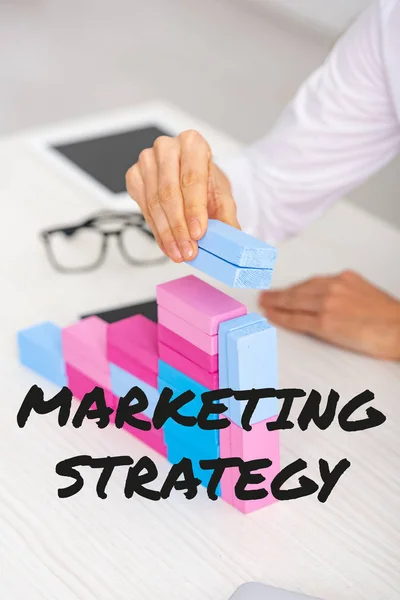 Cropped view of businesswoman making marketing pyramid from colorful building blocks on table, marketing strategy illustration — Stock Image Cropped View Businesswoman Making Marketing Pyramid Colorful Building Blocks Table Royalty Free Stock Photos