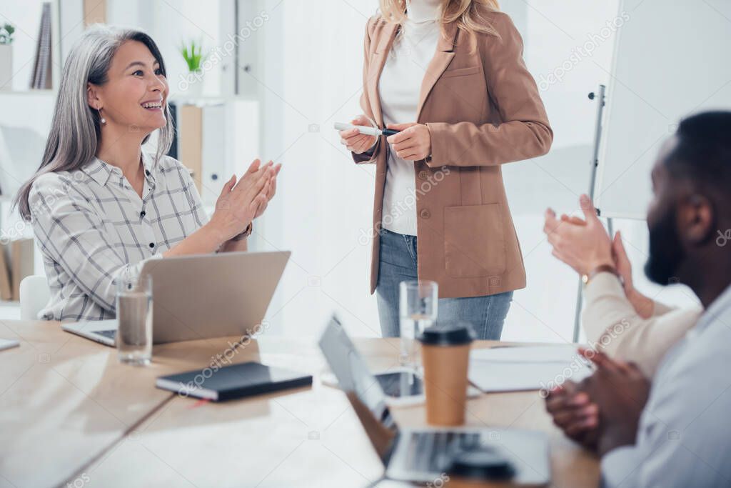 selective focus of smiling asian businesswoman clapping with multicultural colleagues 