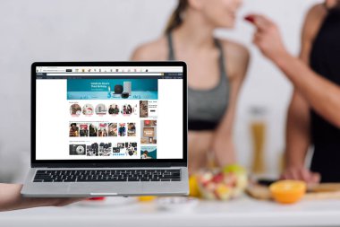 Kyiv, Ukrayna - 28 Aralık 2019: Mutfakta Amazon web sitesi bulunan çift dizüstü bilgisayarın seçici odak noktası 