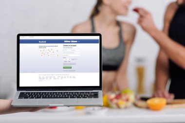 Kyiv, Ukrayna - 28 Aralık 2019: facebook sitesi mutfaktaki çifte yakın olan dizüstü bilgisayarın seçici odak noktası 