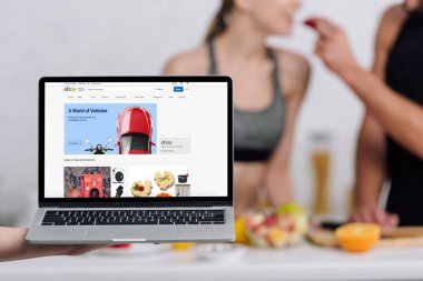 Kyiv, Ukrayna - 28 Aralık 2019: bilgisayarın seçici odak noktası ve e-bay web sitesi mutfakta bir çifte yakın. 