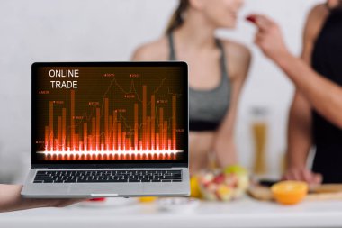 Bilgisayarın seçici odak noktası. Mutfaktaki çiftin yanında çevrimiçi ticaret ekranında. 