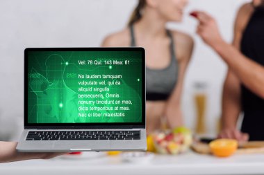 Bilgisayarın seçici odak noktası. Mutfaktaki bir çiftin yanında tıbbi web sitesi var. 