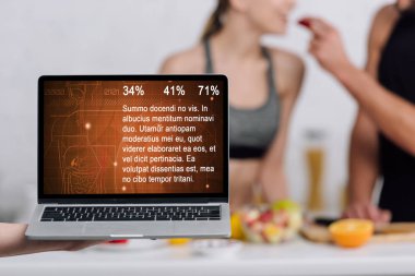 Bilgisayarın seçici odak noktası ve sağlık web sitesi mutfaktaki çiftin yanında ekranda 