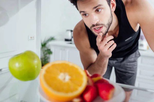 Foco Seletivo Homem Pensativo Olhando Para Frutas Geladeira — Fotografia de Stock