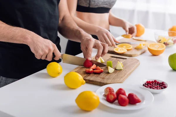 フルーツサラダを作る男と女のクロップドビュー — ストック写真