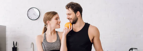 Panoramic Shot Happy Girl Holding Orange Looking Cheerful Man — Stock Photo, Image