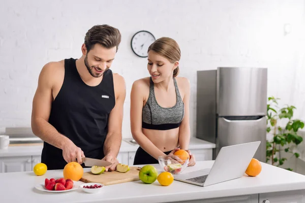 Happy Man Cutting Apple Girl Sportswear Laptop — Stock Photo, Image