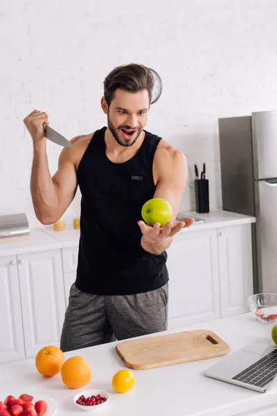 Hombre Guapo Con Cuchillo Sosteniendo Manzana Cerca Frutas Portátil —  Fotos de Stock