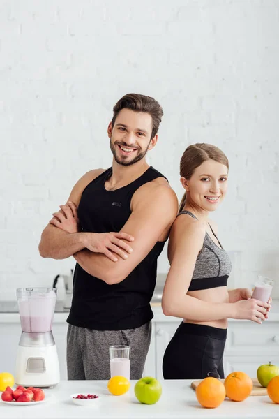 Athletic Man Crossed Arms Happy Woman Smoothie Glass — Stock Photo, Image