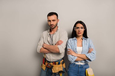 Hüsrana uğramış el işçileri gri kollarıyla ayakta duruyorlar. 