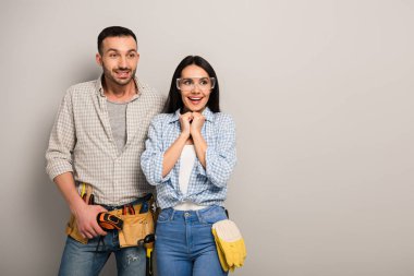 Gri üzerine alet kemeri takmış gözlüklü heyecanlı el işçileri 