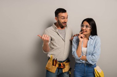 Korkmuş el işçileri griyi işaret ederek konuşuyor. 