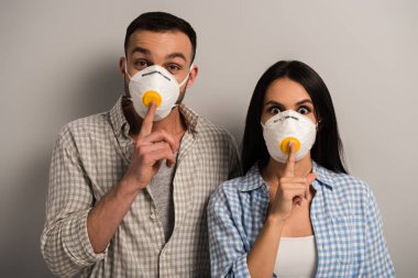Gri renkte sessizlik sembolleri gösteren güvenlik maskeleri takan el işçileri 