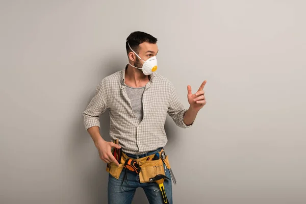 Trabalhador Manual Chocado Máscara Segurança Com Cinto Ferramentas Apontando Para — Fotografia de Stock