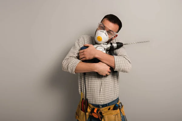 Ευτυχής Χειρωνακτικός Εργαζόμενος Μάσκα Ασφαλείας Αγκαλιάζει Ηλεκτρικό Τρυπάνι Γκρι — Φωτογραφία Αρχείου