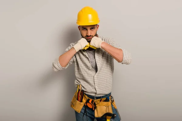 Knappe Werkman Met Helm Handschoenen Met Gereedschapsriem Aan Grijs — Stockfoto