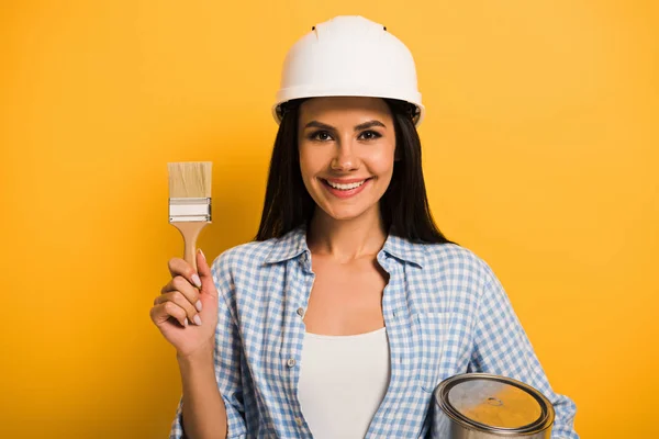 Sonriente Trabajadora Casco Sosteniendo Lata Pintura Pincel Amarillo — Foto de Stock