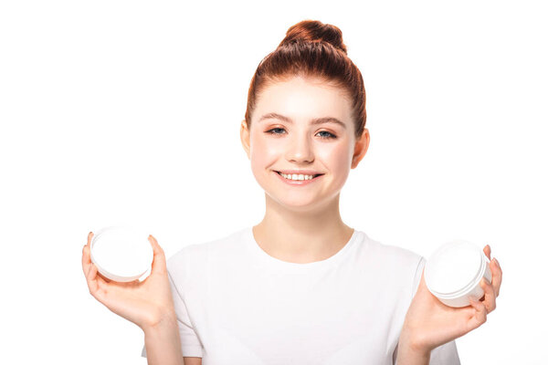 positive teenager with perfect skin holding plastic container with cosmetic cream, isolated on white