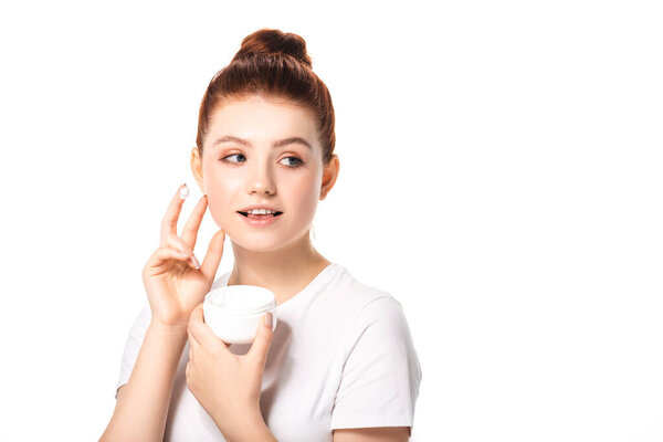 smiling teen girl with perfect skin applying cosmetic cream, isolated on white